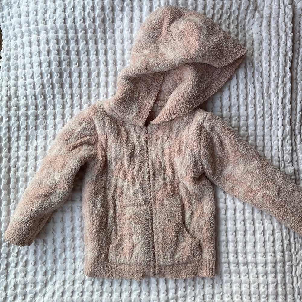 Barefoot Dreams kids hoodie in pink and white swirl.